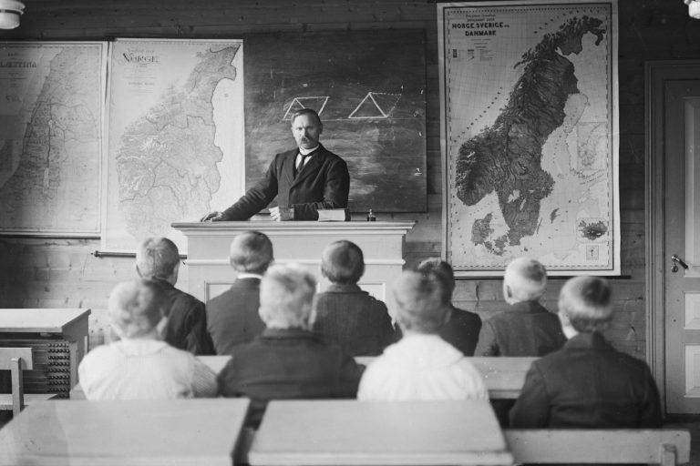 Bild mit Tutor und Schülern vor einer Tafel
